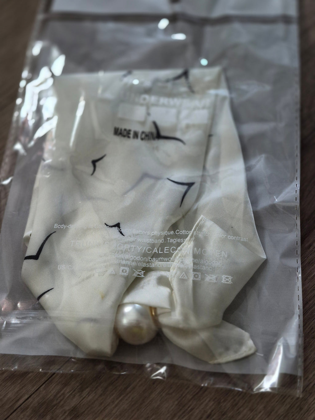 Aria Floral Silk-Feeling Neckerchief Scarf with a Pearl Slide in packaging with pearl detail.